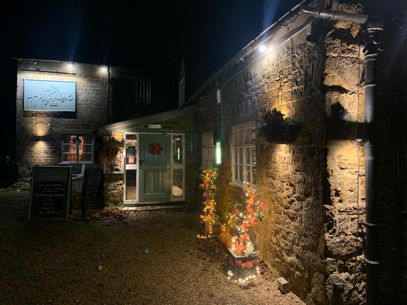 The Hollybush Inn lit up at night